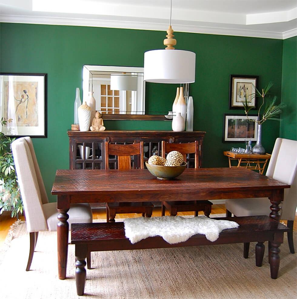 dark wood dining table in a forest green dining room