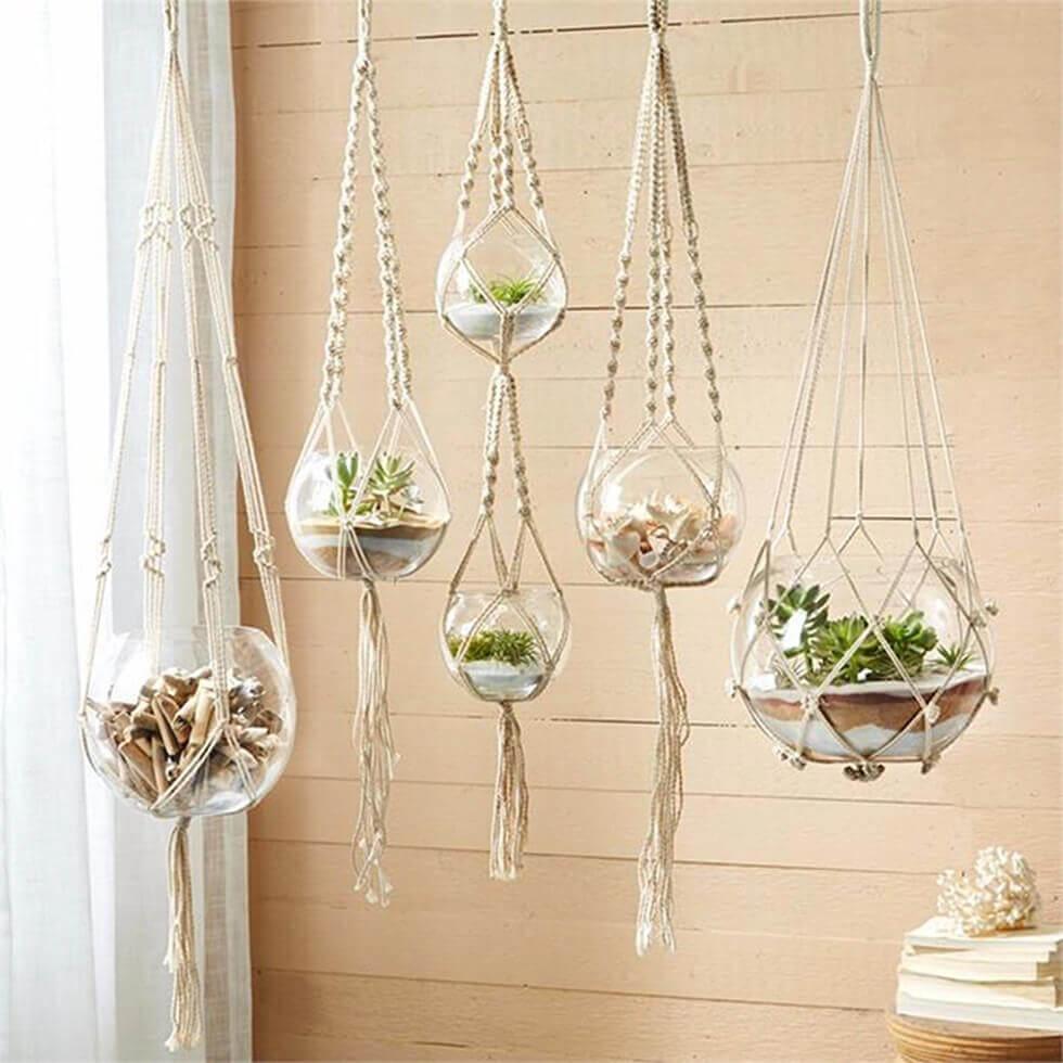 Glass planters suspended from macrame hangings.