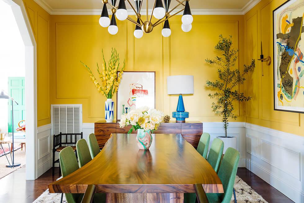 mustard yellow half wall in a modern artsy dining room