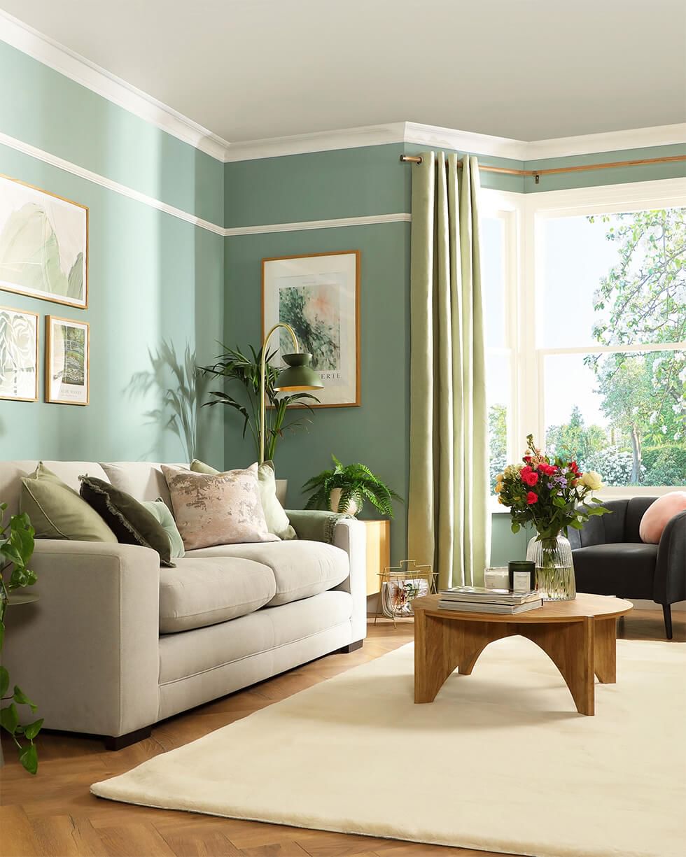 Sage green living room with a bay window feature wall