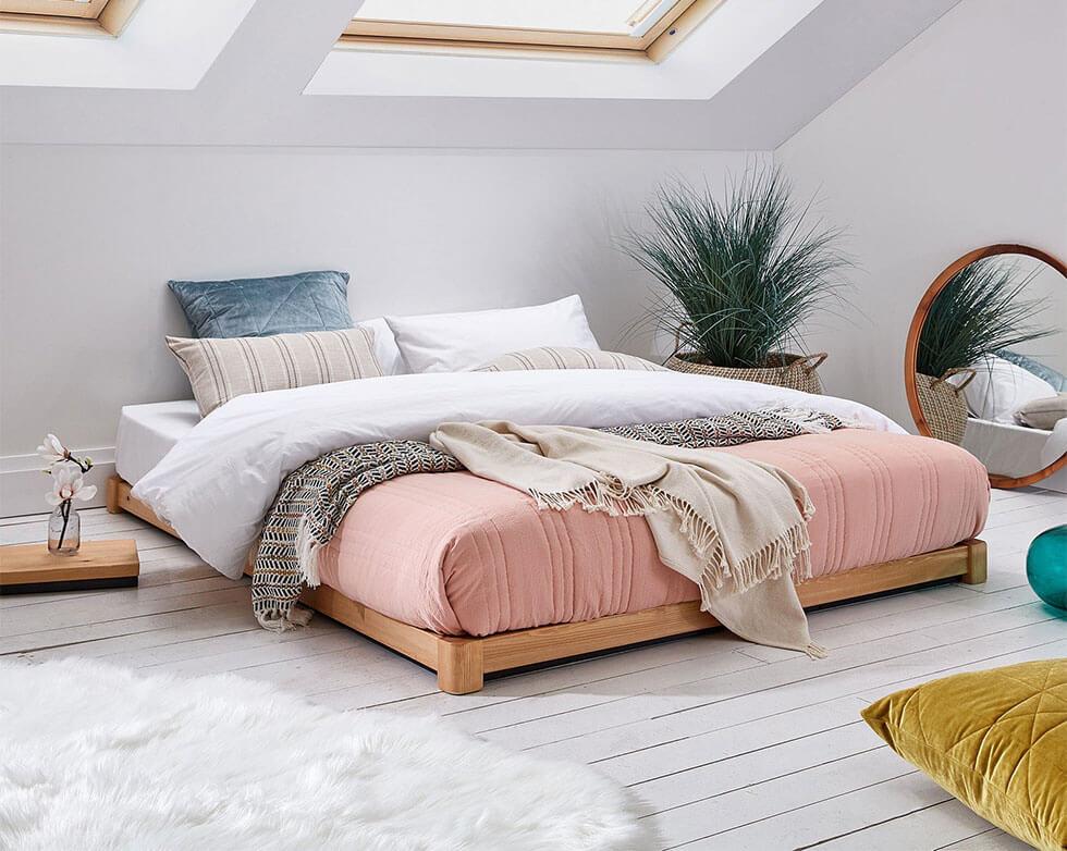 Loft bedroom with coral bedding that has a tropical vibe