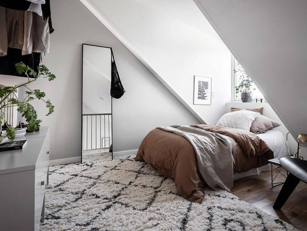 Cosy Scandinavian loft bedroom in a neutral palette