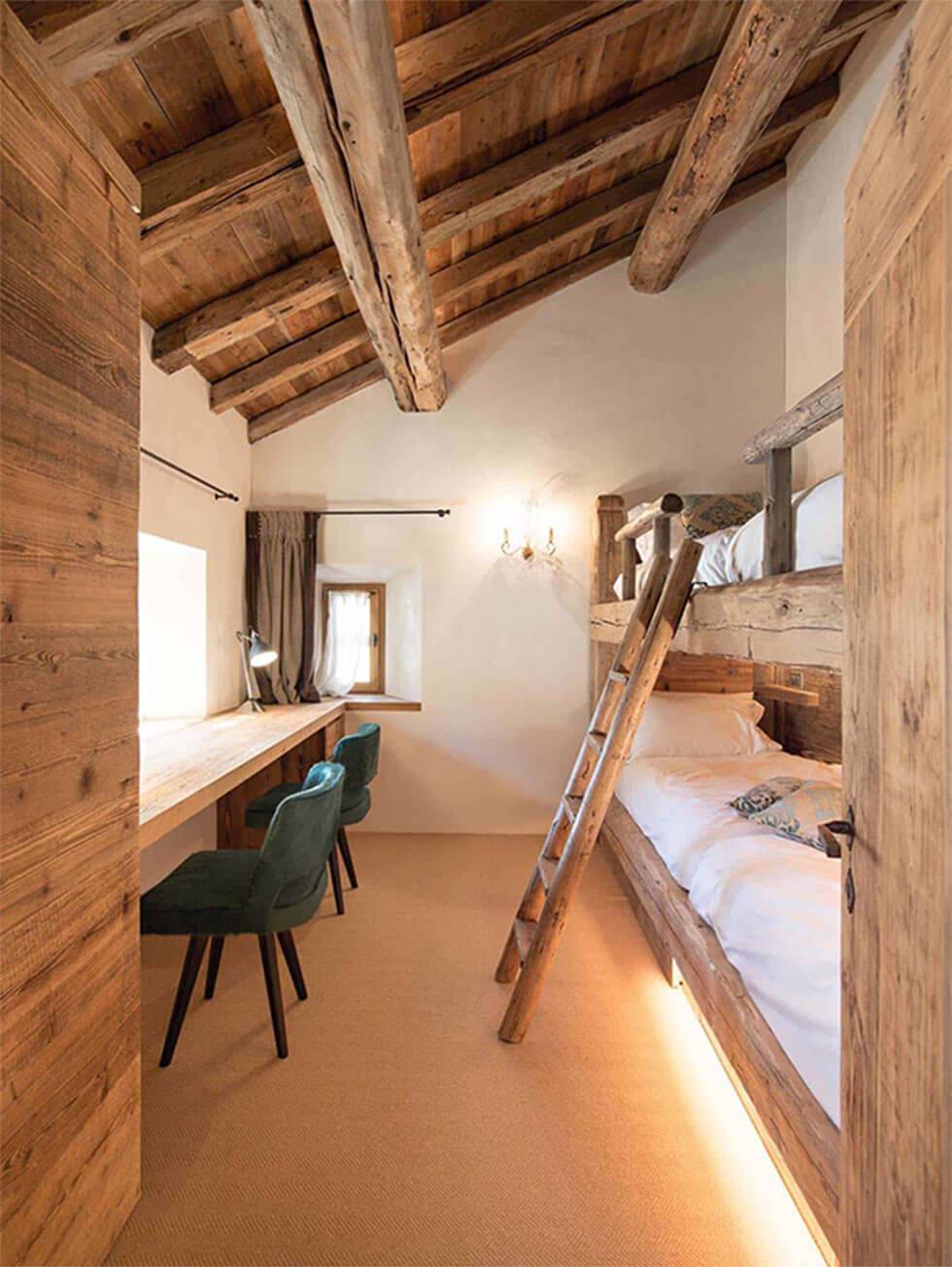 Classic wooden loft bedroom with bunk beds and wooden writing desk