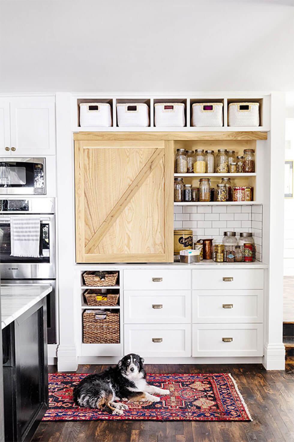 Bright airy small kitchen with lots of storage options, including drawers and shelves, and a colourful rug