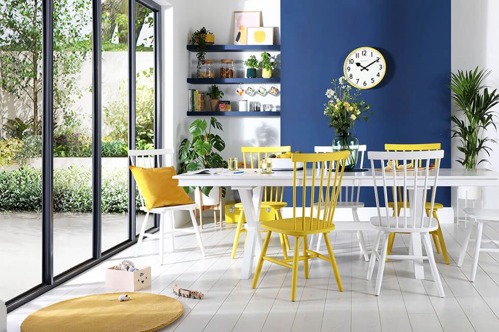 Dining area featuring a white dining set mixed with bright yellow dining chairs