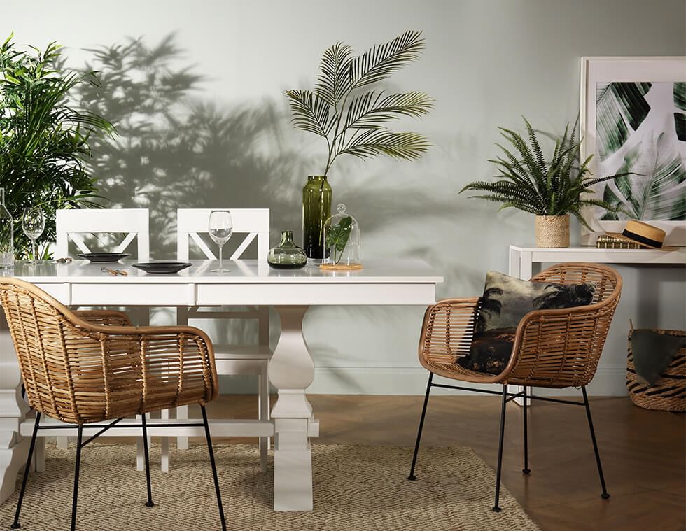 White dining set with wicker chairs in a tropical style dining room