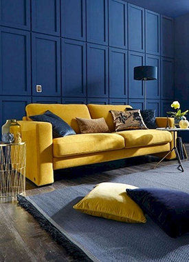 Mustard yellow sofa paired with pantone classic blue walls in a modern living room