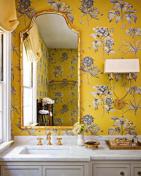 Yellow floral wallpaper in an elegant bathroom with white countertops