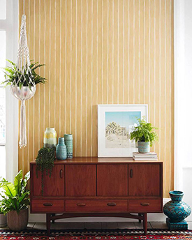 Yellow and white striped wallpaper and a dark wood console table