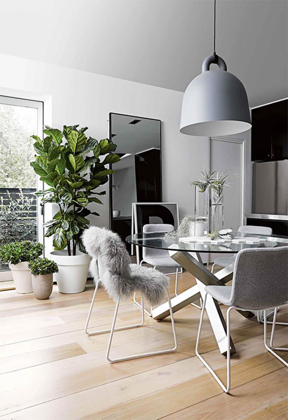 cosy grey dining room with greenery and a faux fur rug