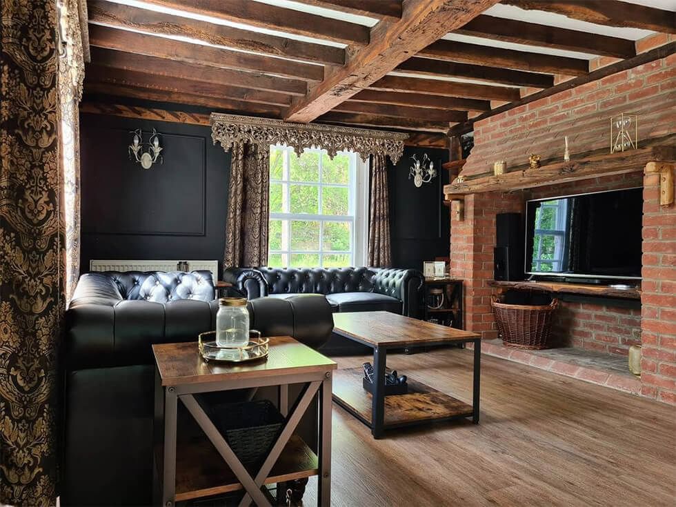 Country style living room with black leather sofas