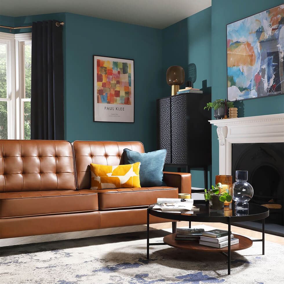 Teal coloured living room with a brown leather sofa