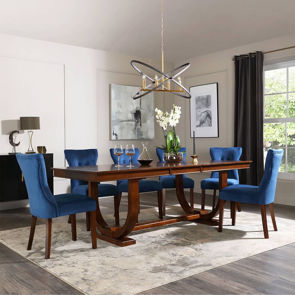 Wooden dining table with blue velvet dining chairs in stylish dining room