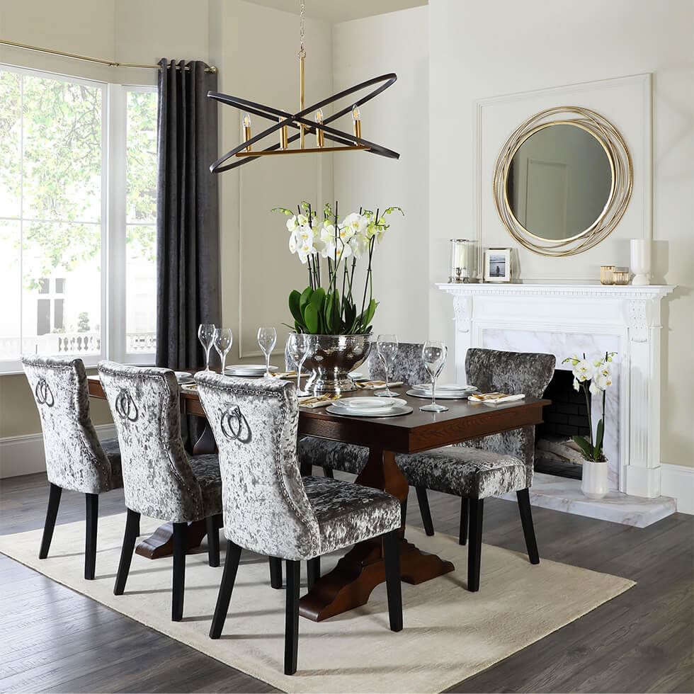Wooden dining table with velvet dining chairs in a luxe dining room