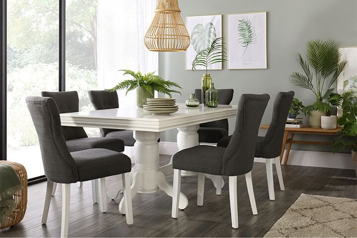 Tropical style dining room with dark grey dining chairs and a white dining table