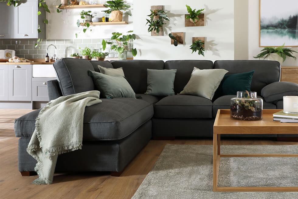 Stylish living room featuring a grey corner sofa and plant wall