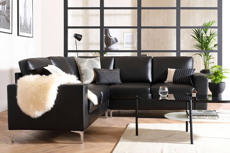 A black leather corner sofa in a modern industrial decor living room