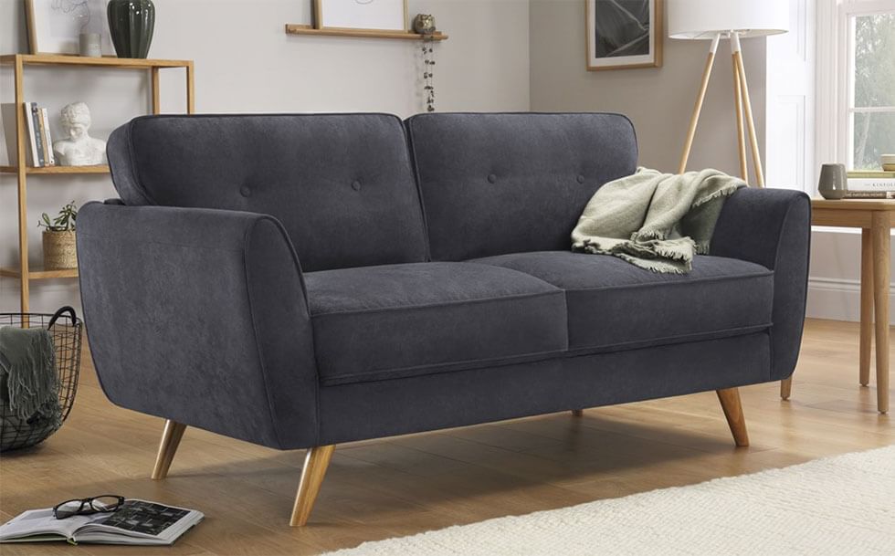 Contemporary grey sofa with wooden legs in a neutral living room.