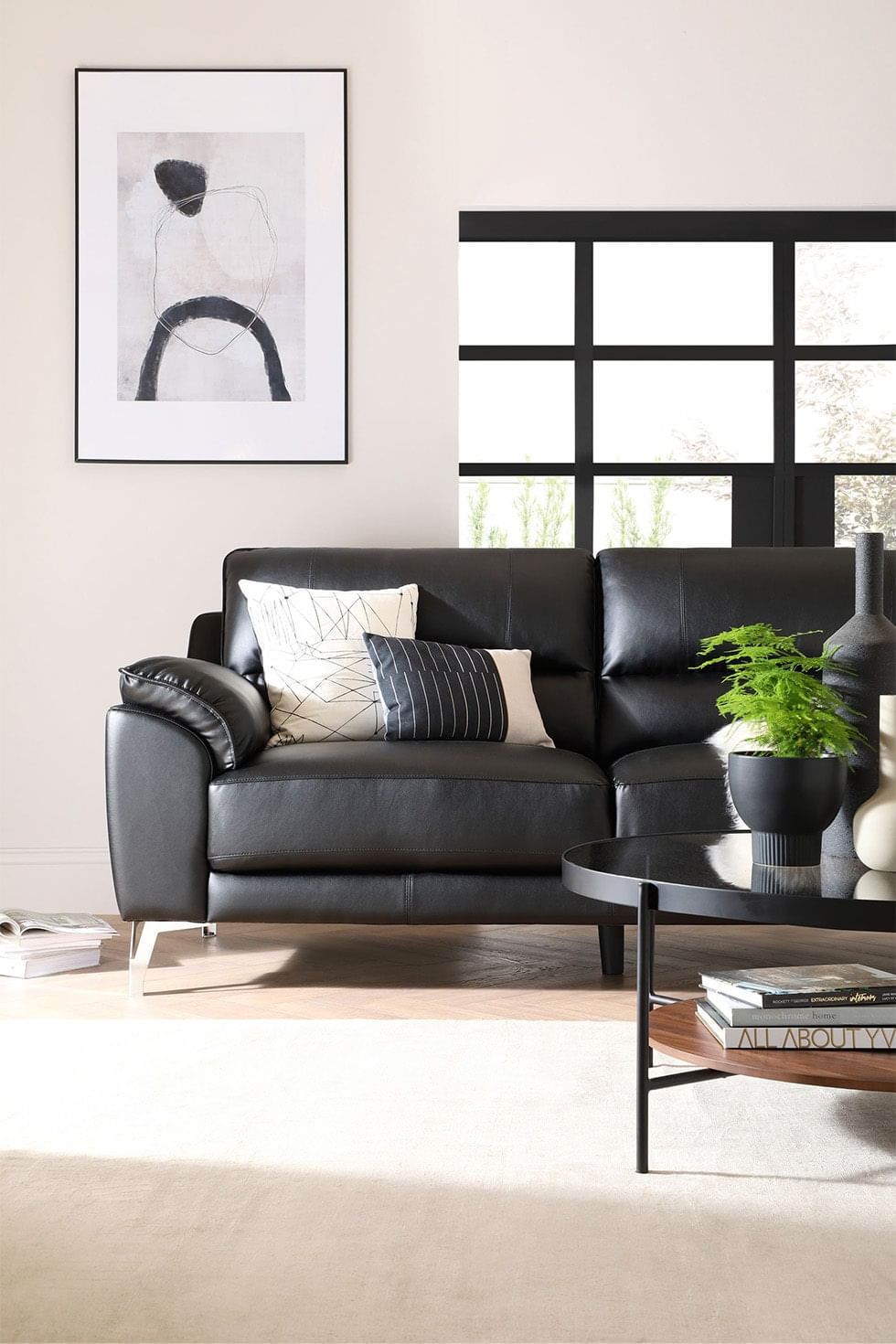Modern industrial living room with black leather sofa
