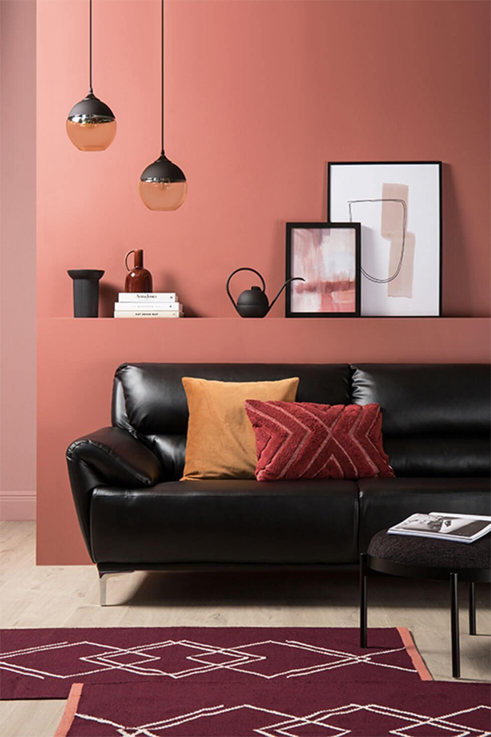 Living room with terracotta walls and black leather sofa