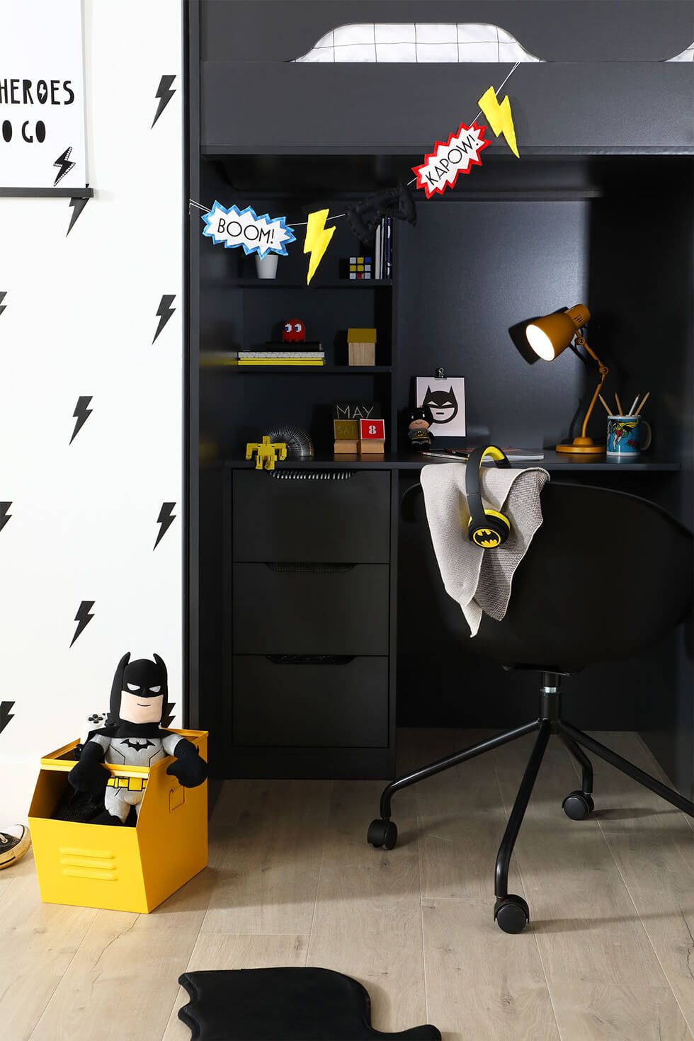 Batman-themed bedroom with black high sleeper bed and cute soft toys