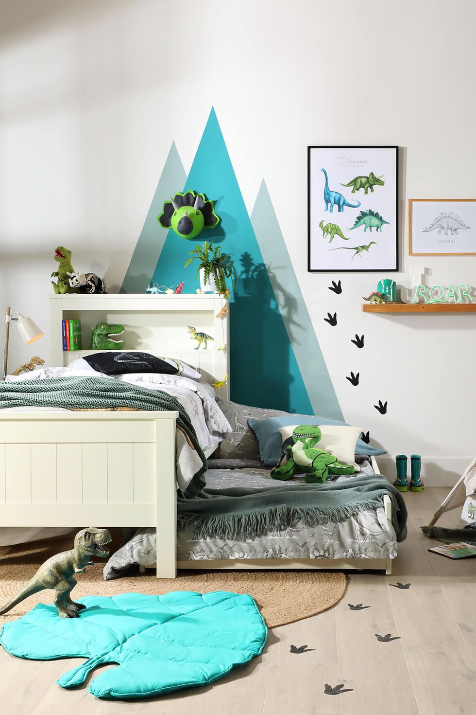 Dinosaur-themed bedroom with trundle bed, soft toys and artwork
