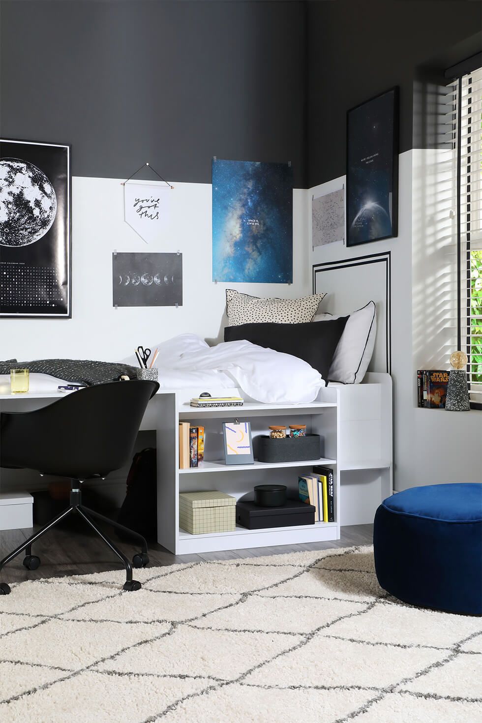 Space-themed bedroom with two-tone walls and galaxy posters