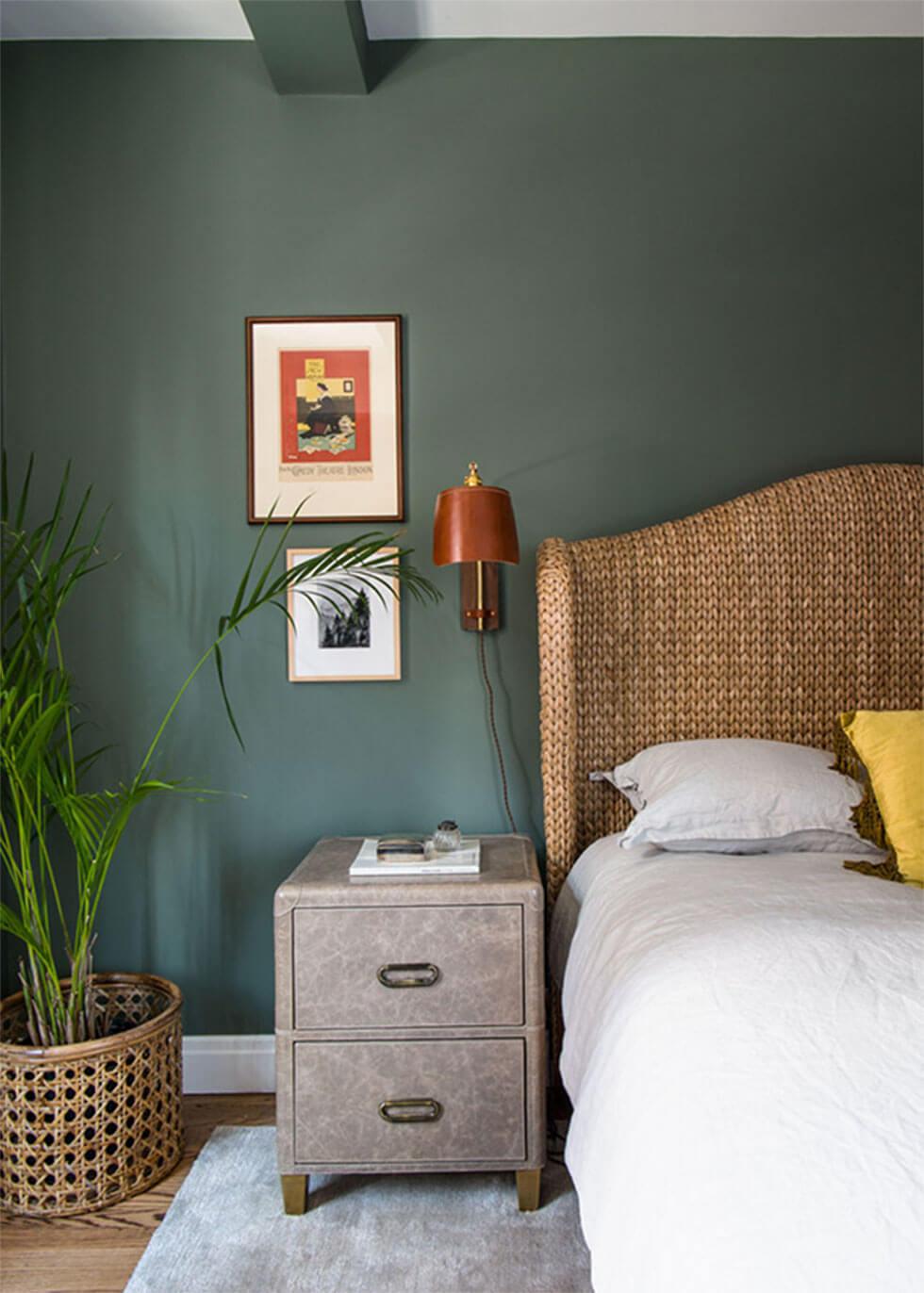 A bedroom wall painted in green, with natural materials around the room.