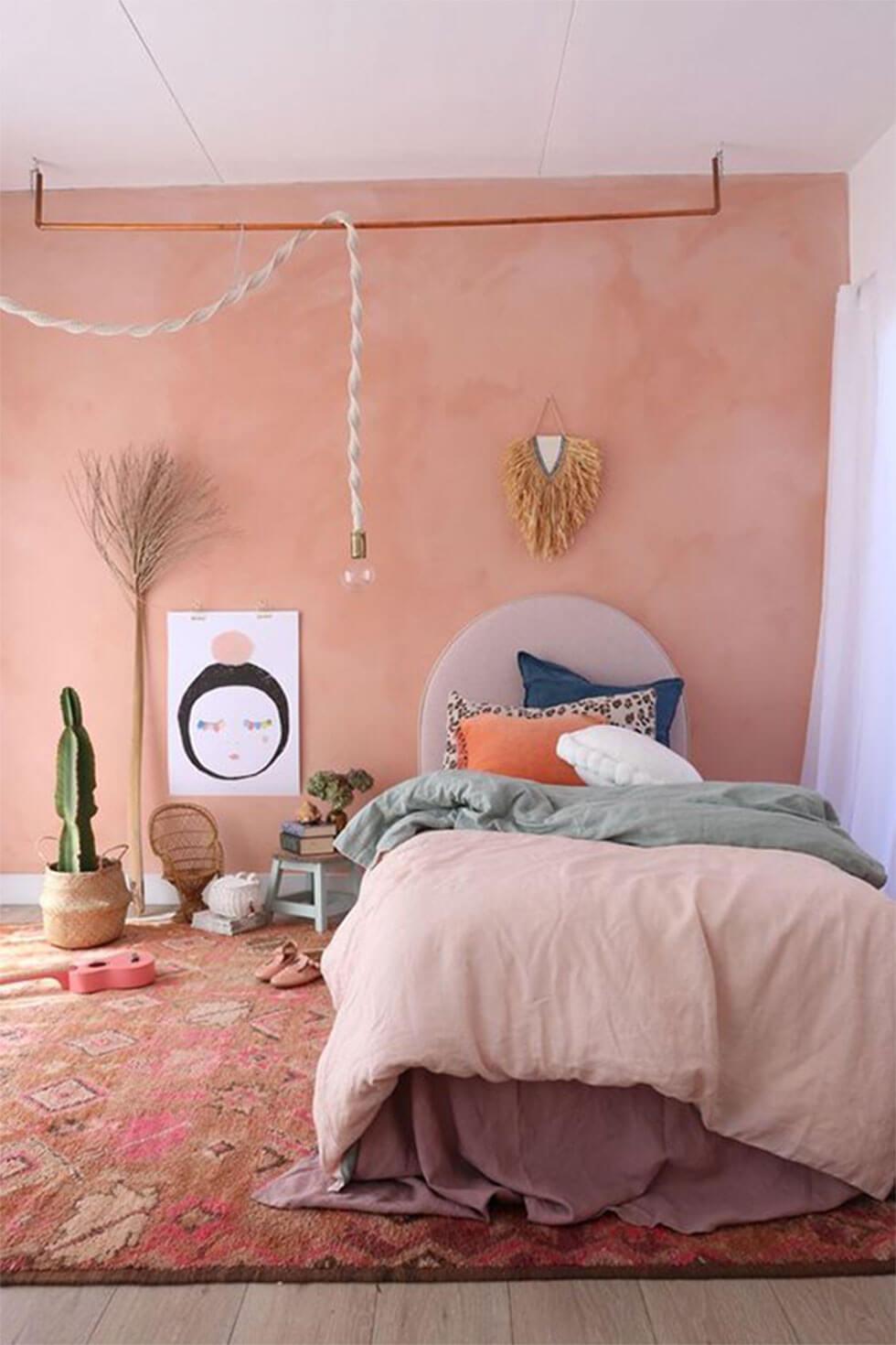 Bedroom walls painted dusky pink with bronze accents for a bohemian glam look.