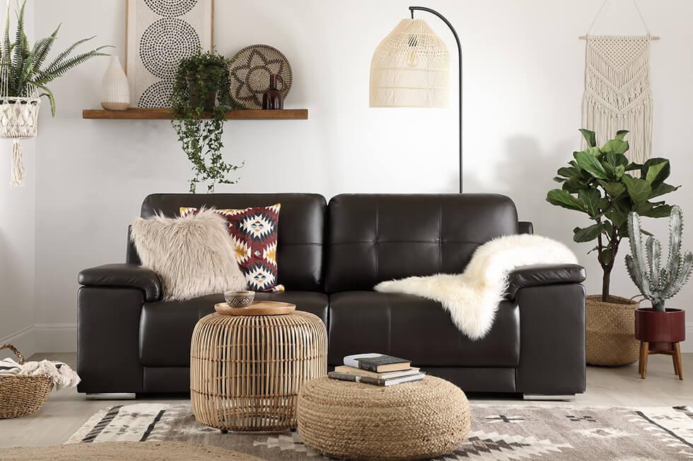 Black leather sofa in a neutral modern boho living room