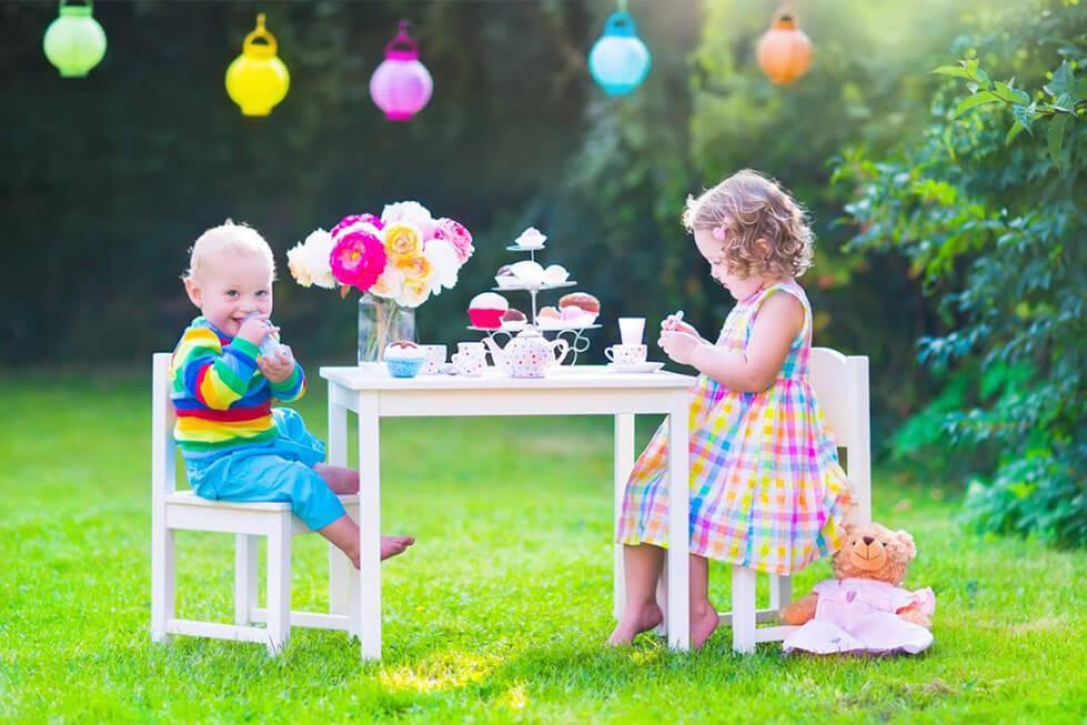 Toddlers having a tea party with soft toys