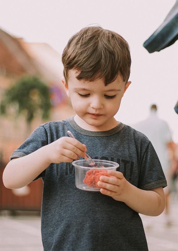 young boy eating with a spoon