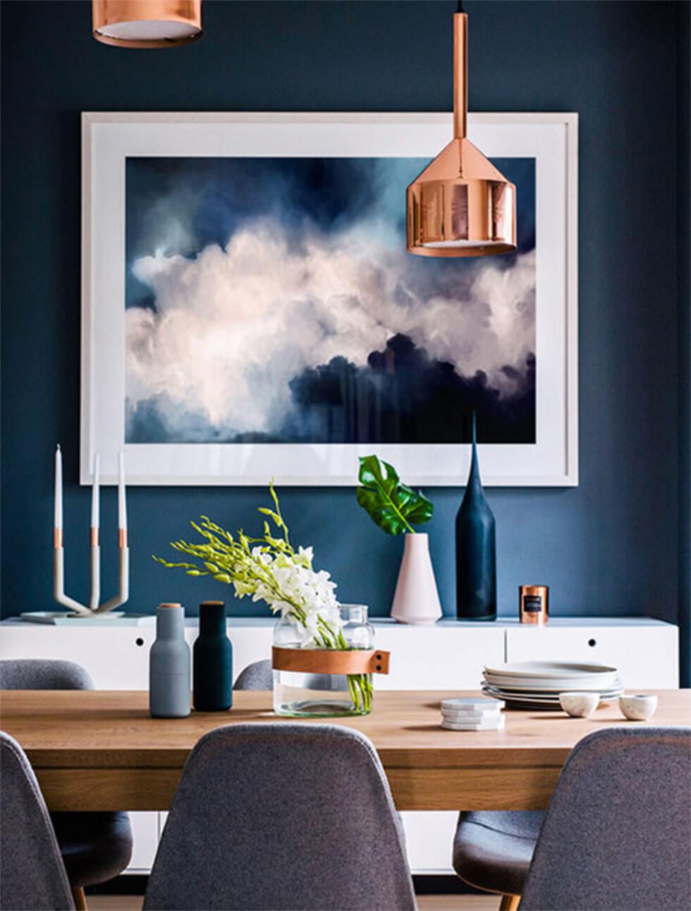 Modern dining room with dark blue backdrop and textured wall hanging