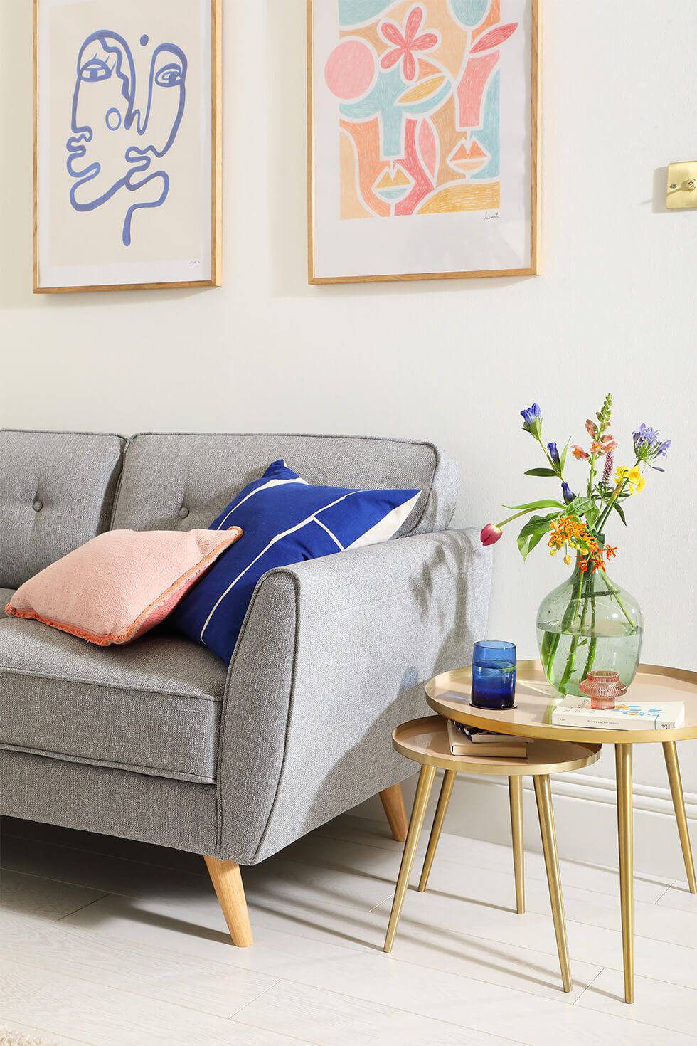 Bright living room with a grey sofa, colourful cushions and a wooden side table