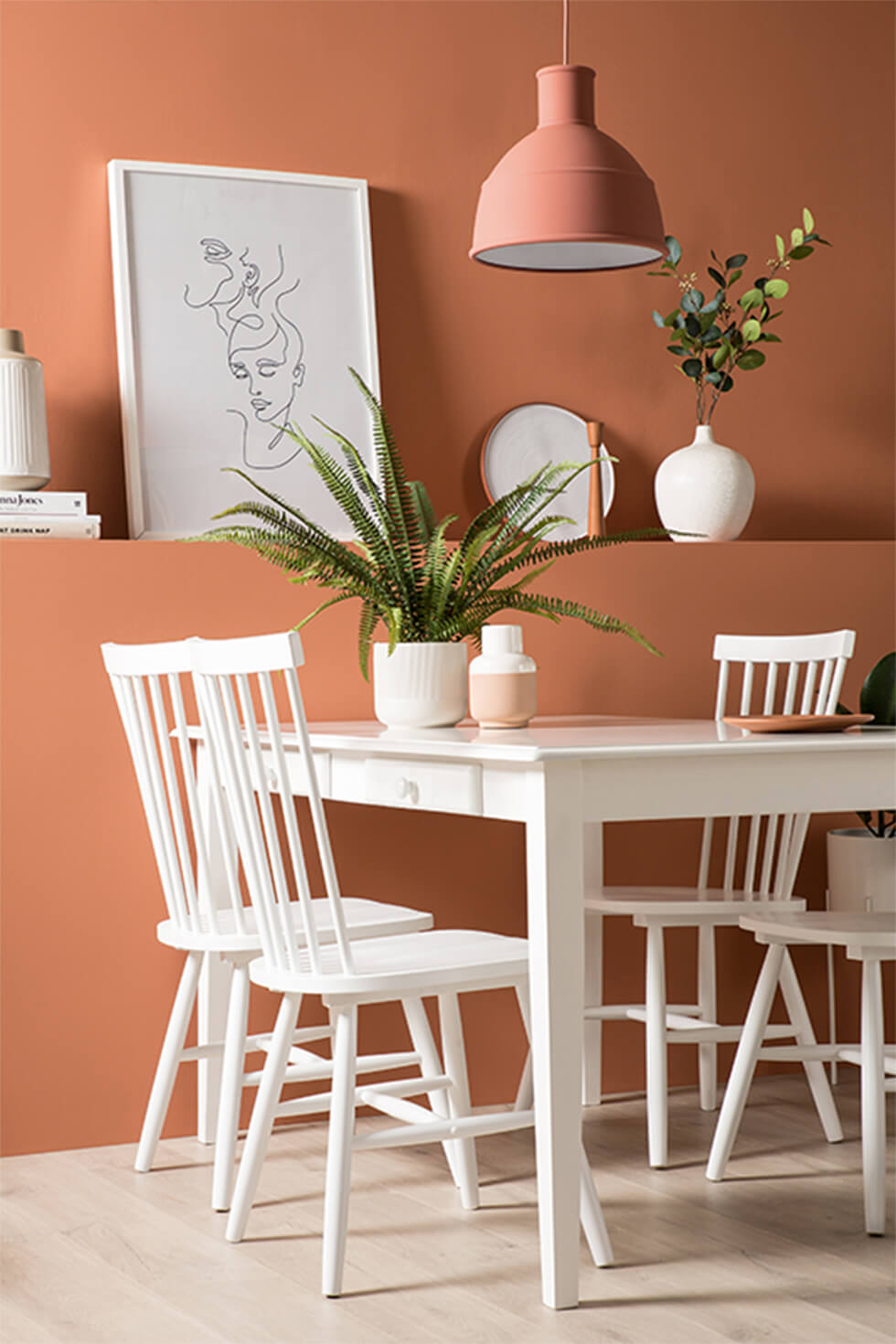 White wooden dining set against terracotta statement wall