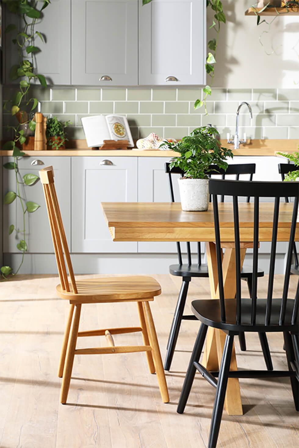 Wooden Windsor chair paired with matching table and black chairs