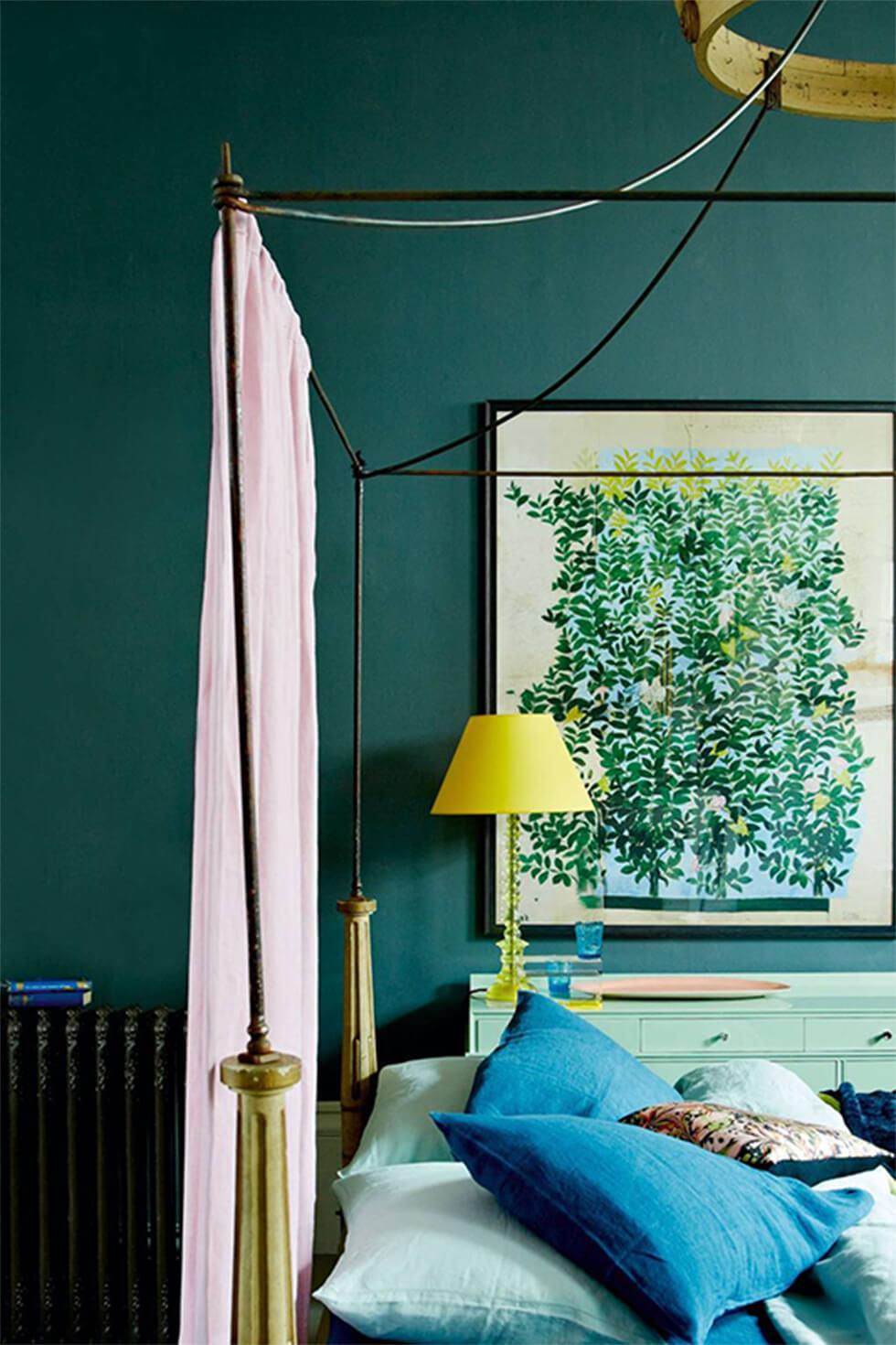 Eclectic teal bedroom with a poster bed, green art, and pink drapes.