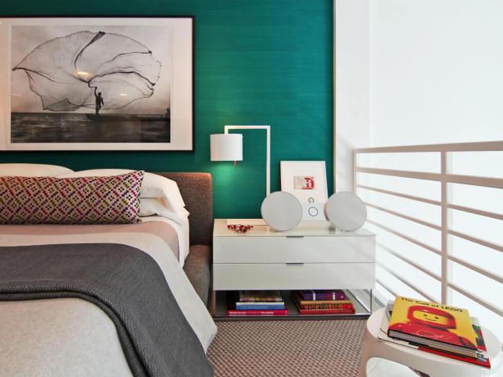 Clean modern teal bedroom with a feature wall and white, minimalist furniture.