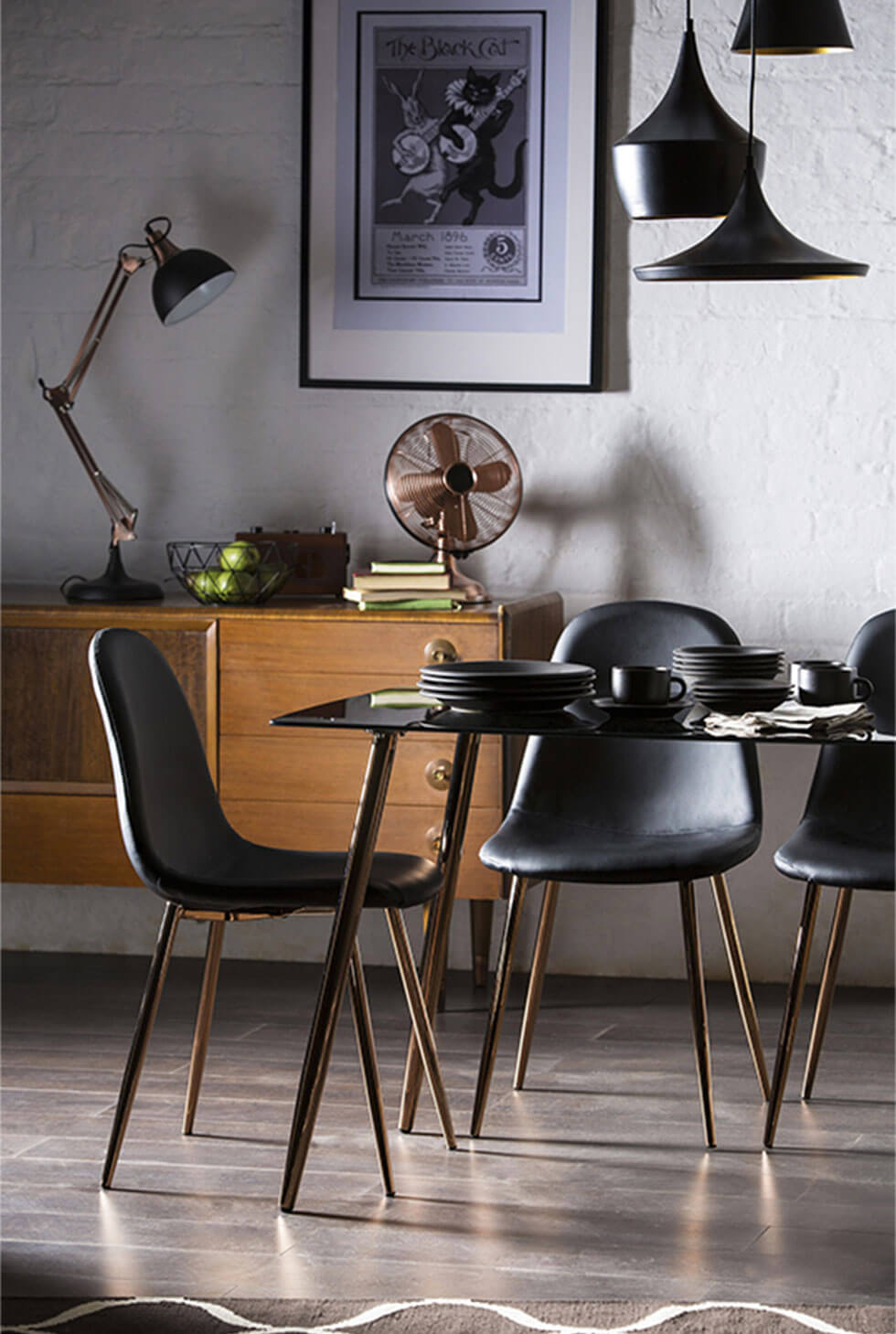 Black dining table and chairs set with copper finished legs in a modern lux setting