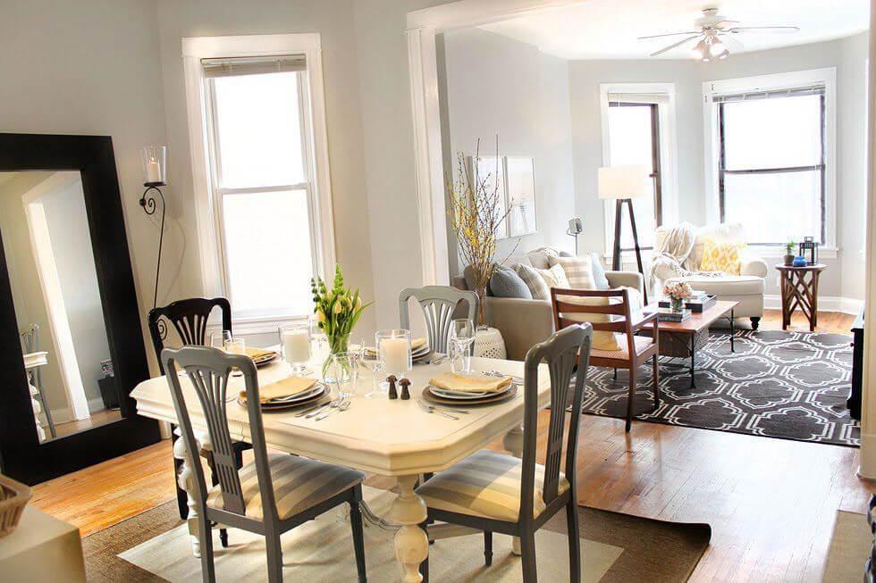 Dining room with wooden dining set, neutral tones, and a large mirror against a wall
