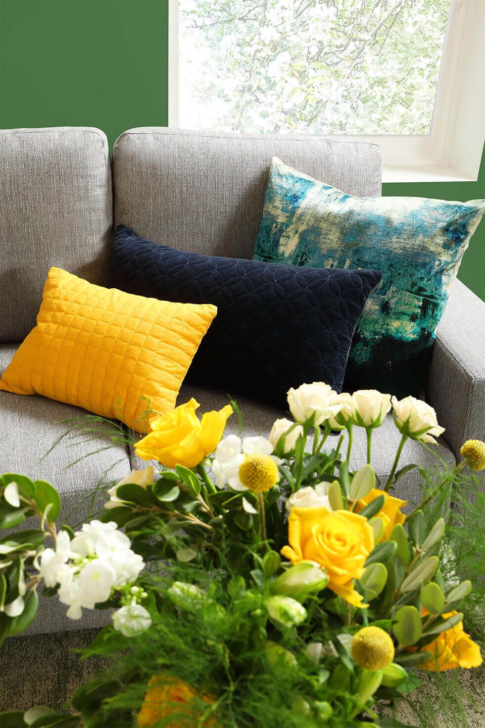 Colourful cushions and floral bouquet in the living room for spring