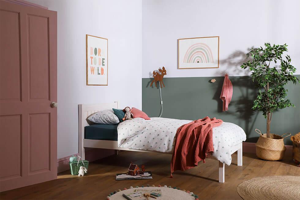 Green and pink children's bedroom with a white wooden bed