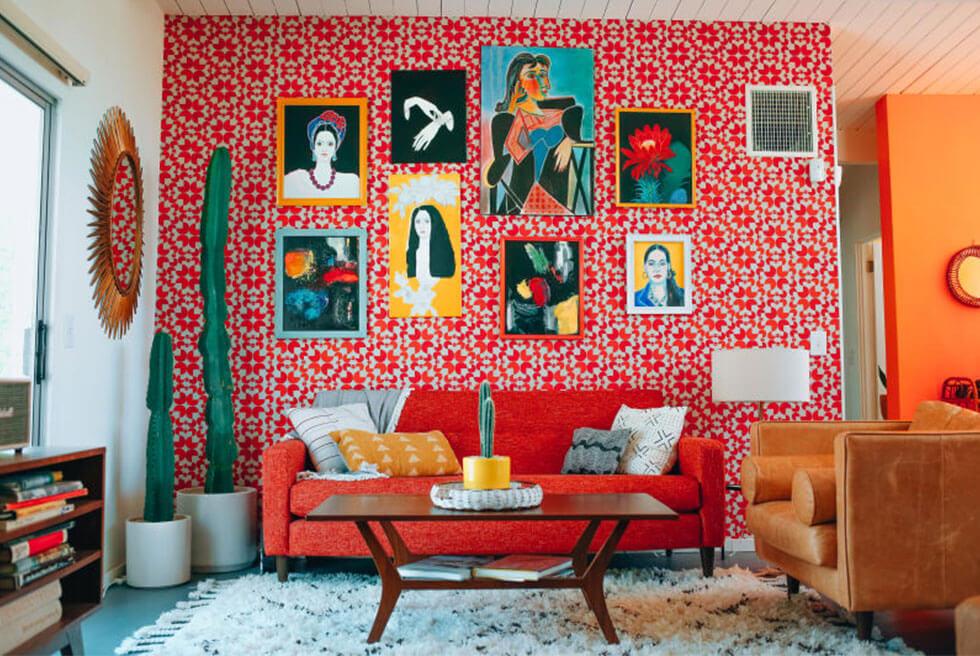 Bold and cosy small living room with high ceilings and colourful artwork hung up top.