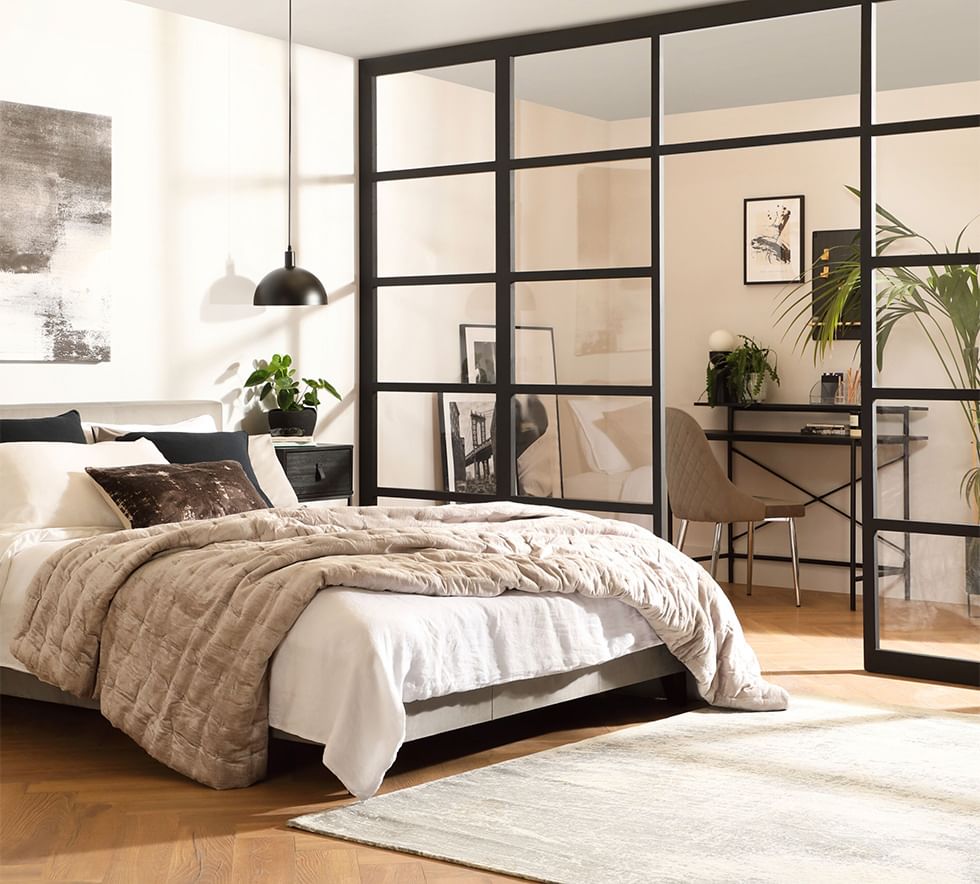 Industrial inspired bedroom with Crittall doors and hardwood flooring