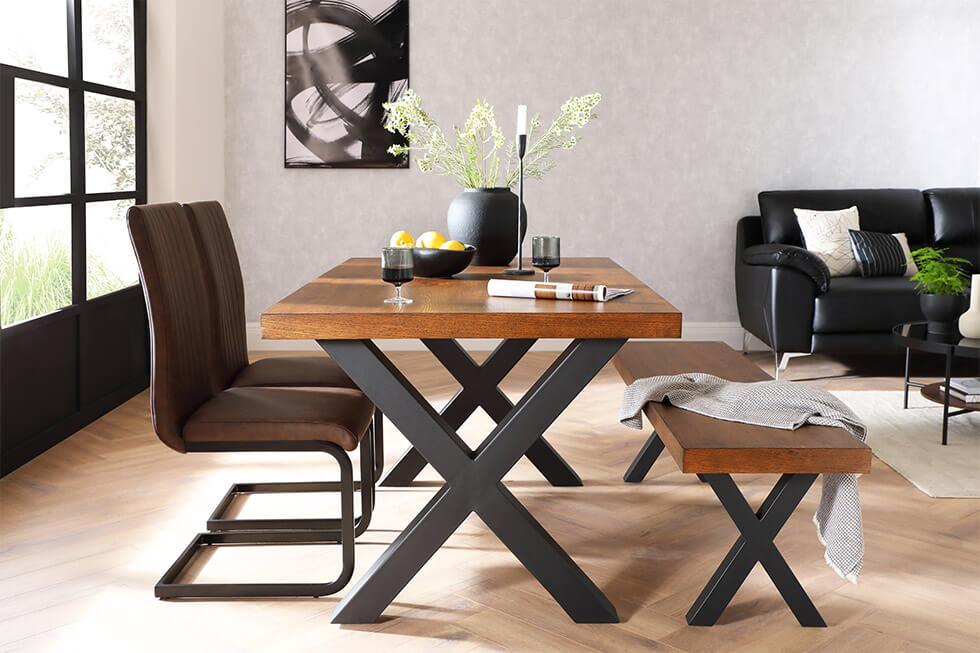 a wood and metal dining set in an open-plan space with a bench and leather chairs