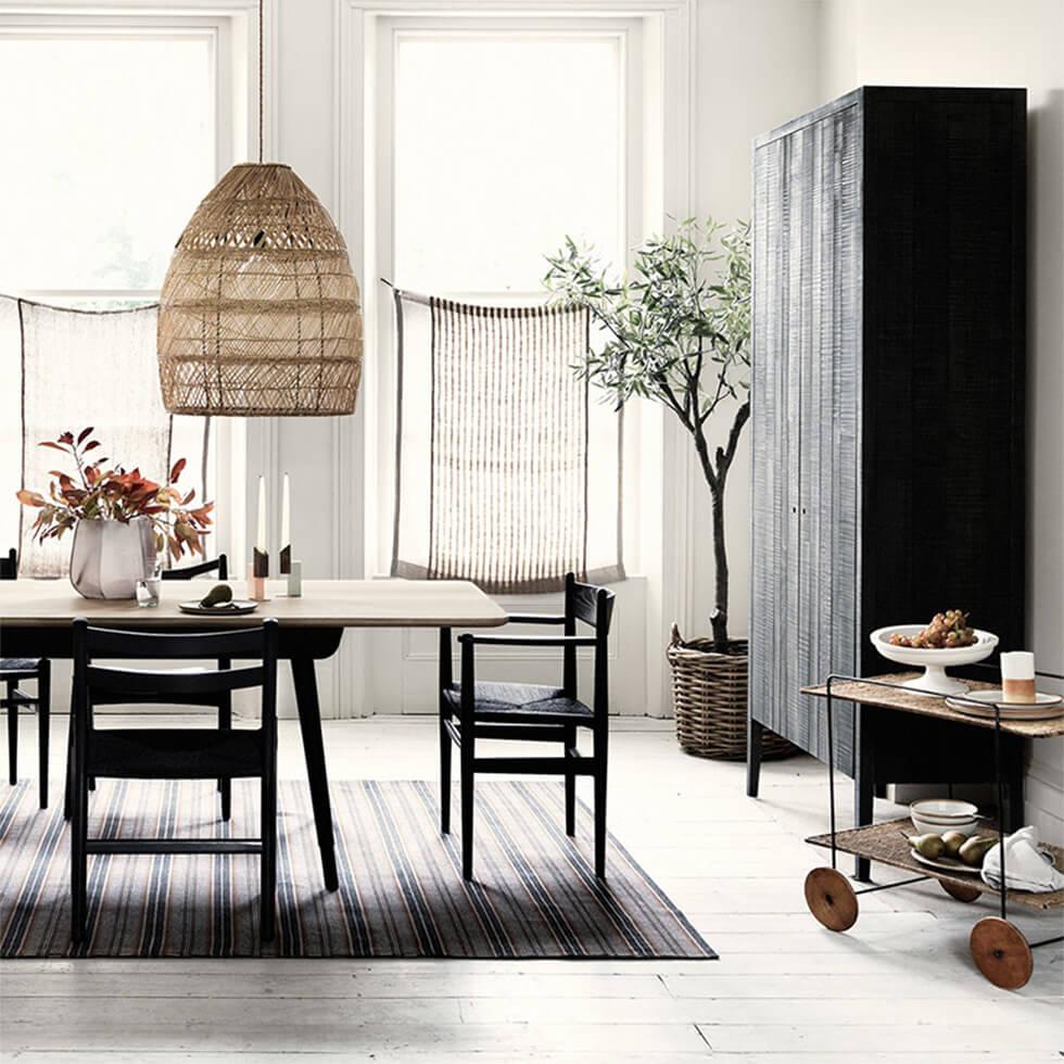 Wooden dining room with woven pendant lamp and large larder cupboard