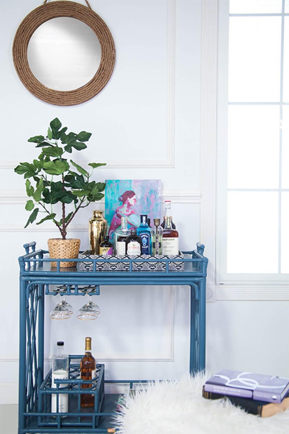 Elegant blue bar cart in a white room with art and plants