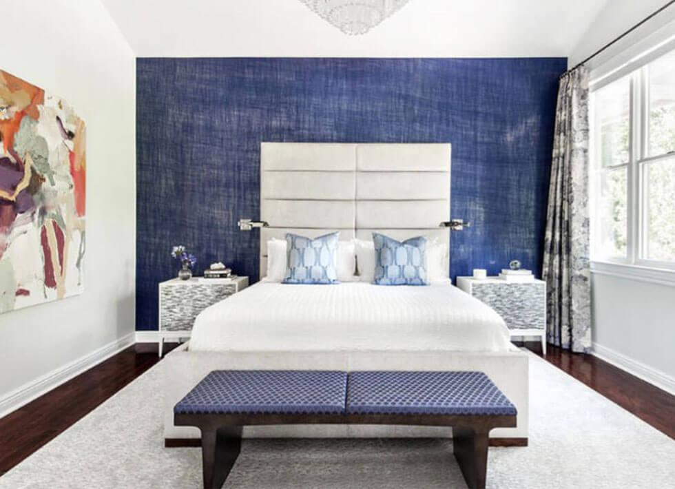 Blue bedroom feature wall with a white bed.