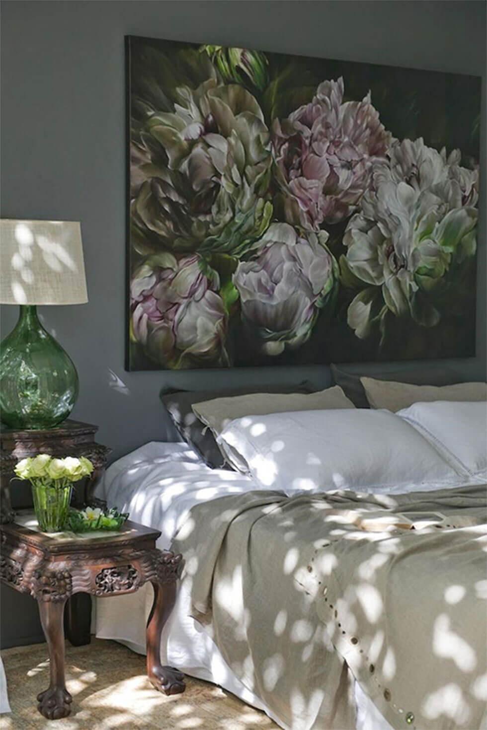 A bedroom wall with large statement artwork framed above the bed.