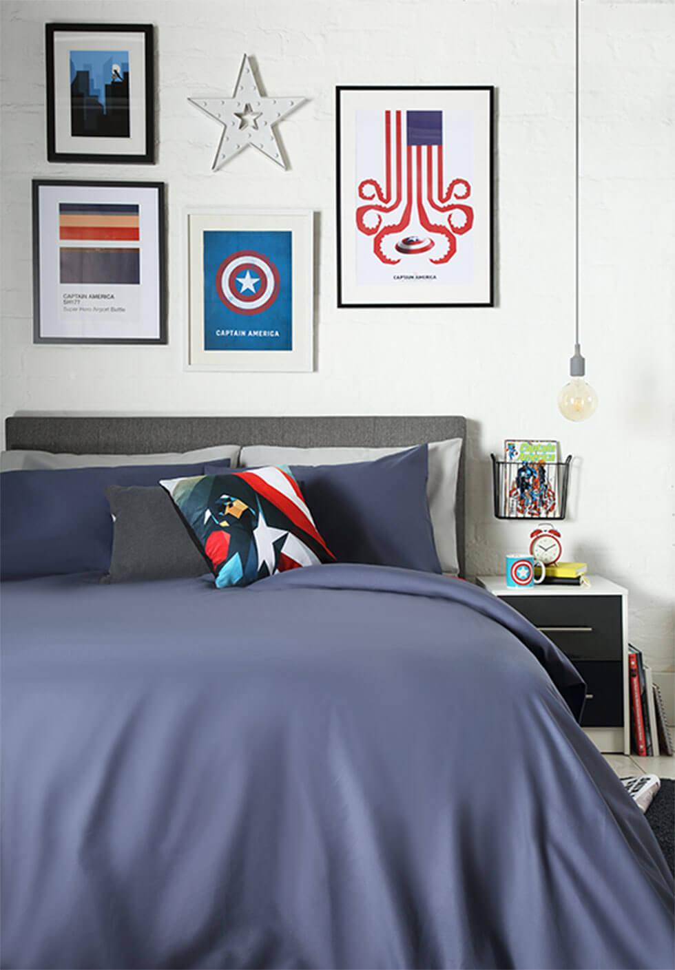 A superhero-themed bedroom feature wall with framed comic book covers and move posters.